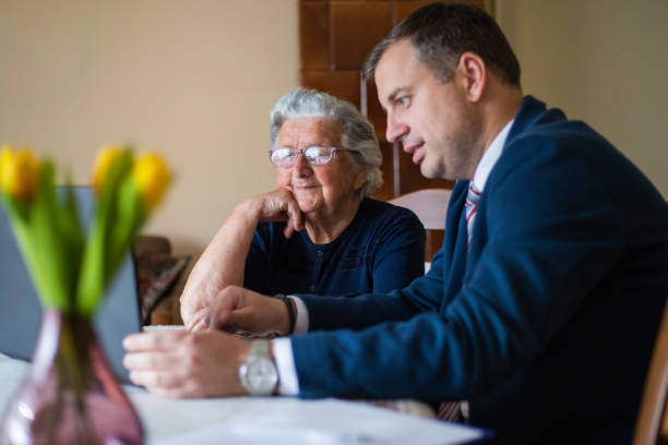 istock Real-estate agent showing homes to his elderly client on laptop 1309701553