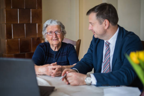 istock Cheerful lawyer looking at his happy elderly client 1309701782