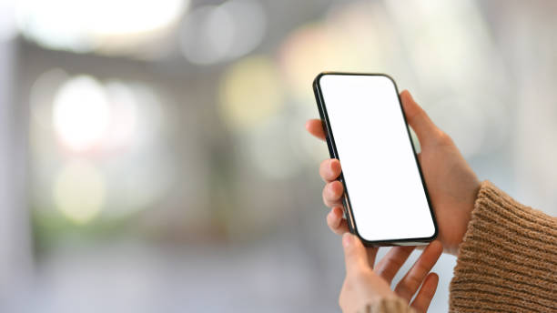 istock Female hand holding mock up smartphone with blurred bokeh background 1309704481