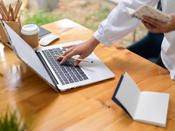 istock Businesswoman working  on her project while holding notebook and typing on laptop computer 1309704509