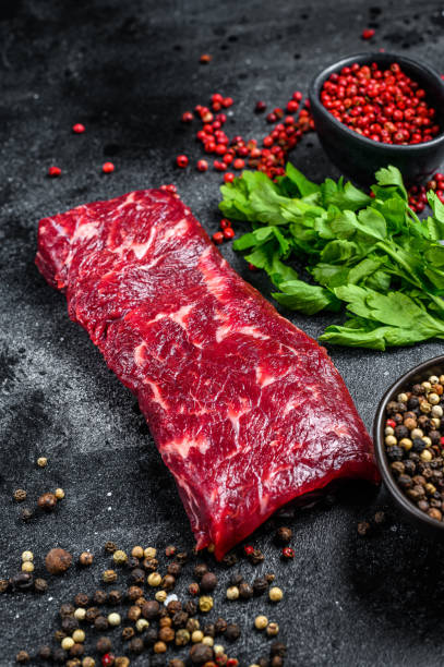 istock Raw marble beef meat steak. Black background. Top view 1309704977