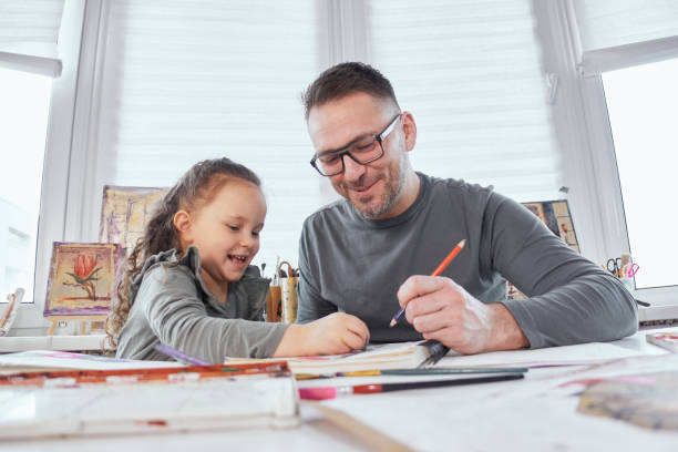 istock Dad helps daughter to draw with colorful crayons 1309705658