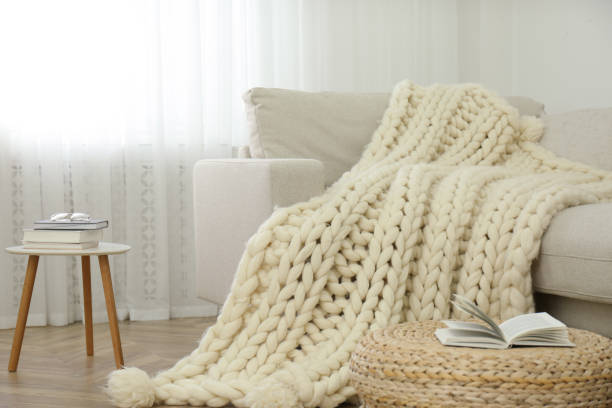 plaid tricoté de laine mérinos sur le sofa dans la pièce - maille photos et images de collection