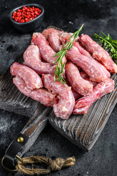istock Raw chicken neck meat on a cutting board. Black background. Top view 1309705716