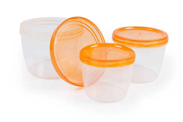 Set of three round reusable translucent plastic food storage and cooking containers different sizes with screw lids orange color for home use on a white background