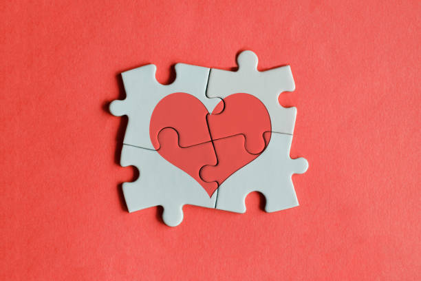 Red heart shape on the jigsaw puzzle pieces. stock photo