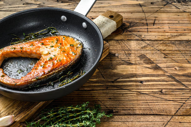 istock Grilled salmon steak in a pan. Wooden background. Top view. Copy space 1309706497
