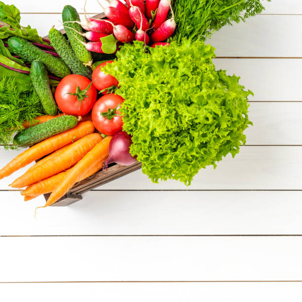 Doorstep Delivery Service: Cardboard box full with organic groceries at kitchen desk.
