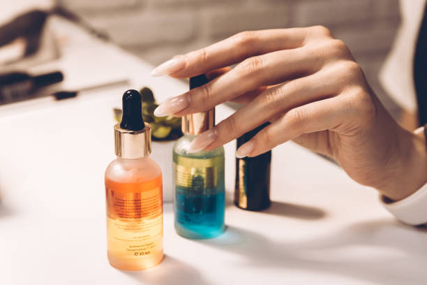 istock Manicure master table with tools for work. Woman's hand, beautifully designed jars of cuticle oil, nail polish and a brush in the background and space for text or logo. 1309709370