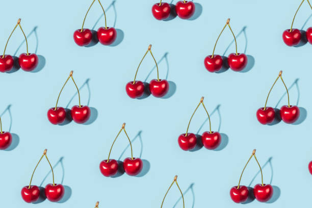 istock Bright pattern of ripe cherries on a blue background. 1309709544