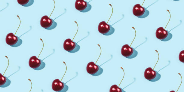 istock Bright pattern of ripe cherries on a blue background. 1309709556