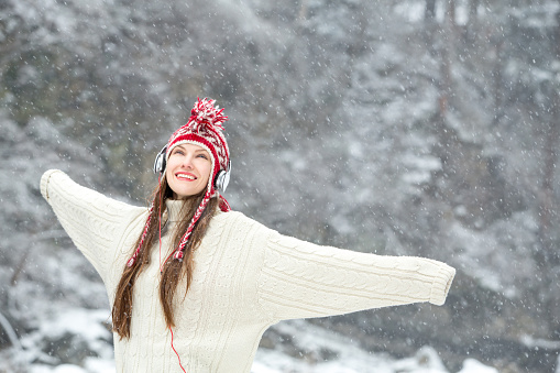 Girl listening to music in winter scenery