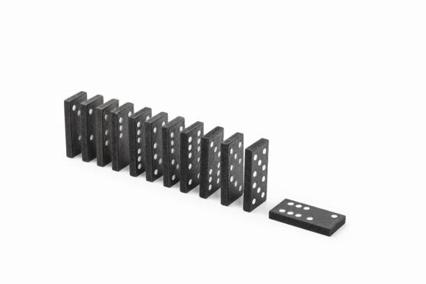 istock Standing domino pieces and one falled on a white background 1309710423