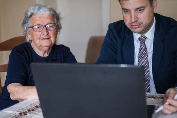 istock Serious lawyer looking at laptop along with his elderly client 1309710774