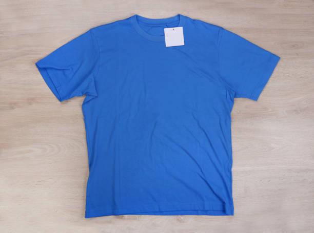 istock Front blue tshirt with label on wooden background 1309713936
