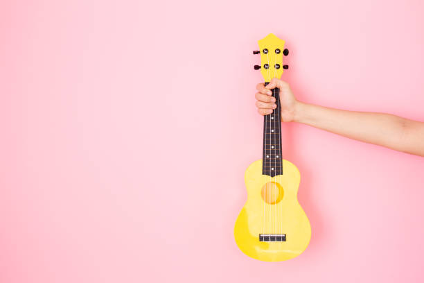 счастливая азиатская женщина, держащая в руках акустическую гитару укулеле. - 20s acoustic guitar adult art стоковые фото и изображения
