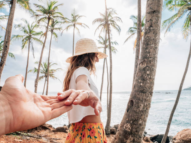 istock Couple holding hands on mountain palm tree hill 1309715832