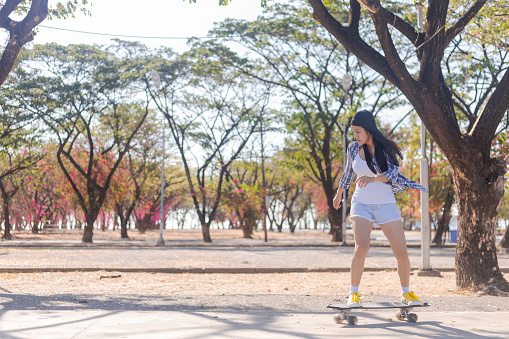 Young asian women play surf skate board at park skate ramp outdoors on morning. Happy women play surfskate board at park . Sport activity lifestyle concept