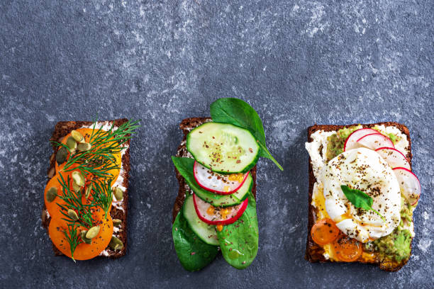 istock three vegetarian toasts with poached eggs, cottage cheese, yellow tomatoes, radish, cucumber, spinach on grey background 1309717893