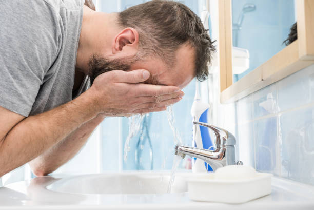 istock Man washing his face in bathroom 1309718806