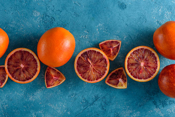 istock red oranges, slices, halves on blue background, food composition, top view, flat lay 1309720309