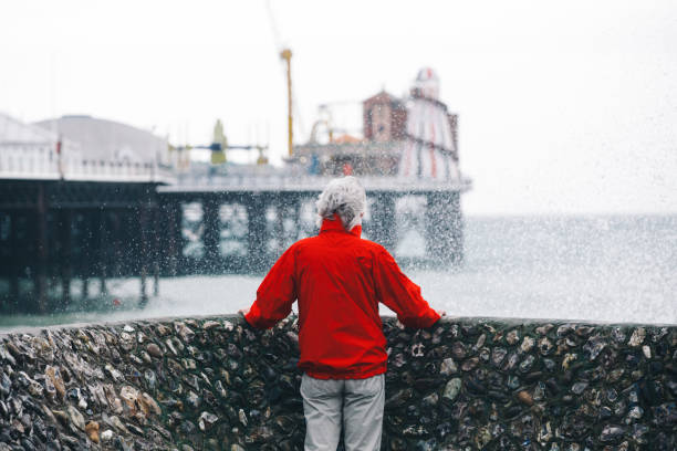 istock Senior man looking out at stormy sea and powerful waves 1309721676