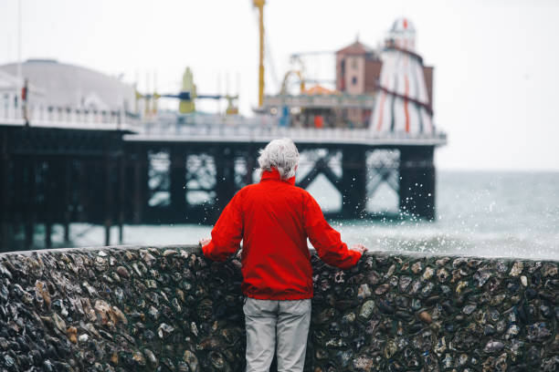 istock Senior man looking out at stormy sea and powerful waves 1309721689