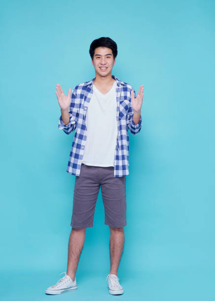 istock Asian handsome man presenting on blue background 1309722283