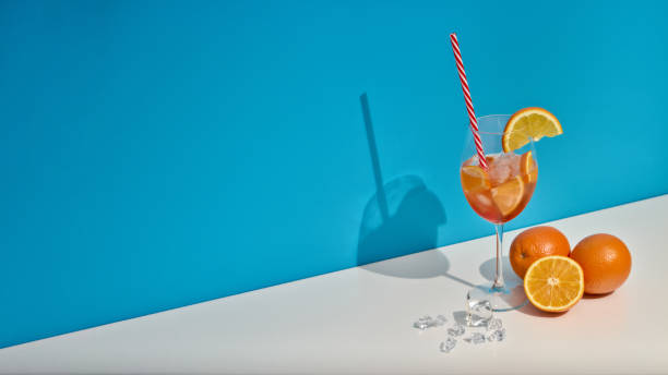 istock Fruit drink with ice and oranges on double white blue background with shadow. Cocktail. Orange juice 1309722308