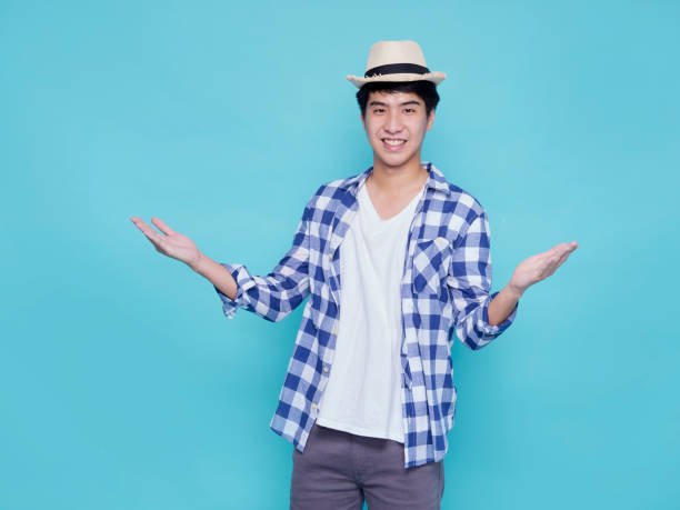 istock Asian handsome man presenting on blue background 1309722559