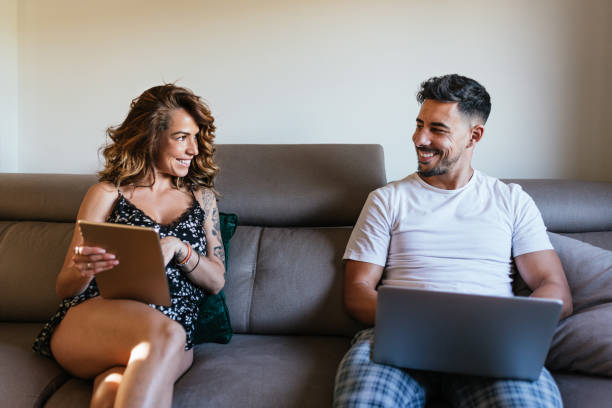 istock couple relaxing at home with electronic devices, tablet and computer. 1309725050