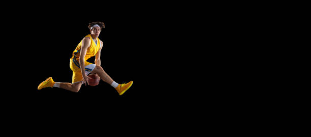 istock Young Caucasian basketball player training isolated on black background. 1309725125
