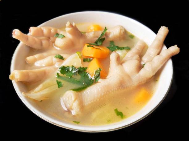istock Chicken feet soup in a white bowl isolated on black background 1309727165