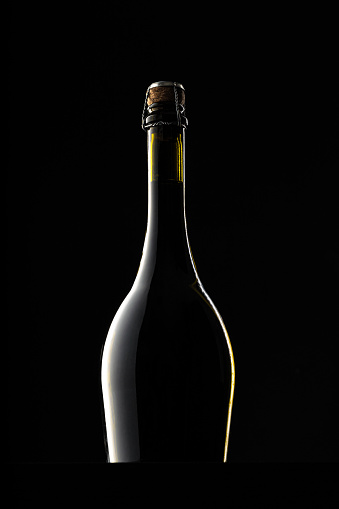 Champagne bottle on black background, copy space. close up.