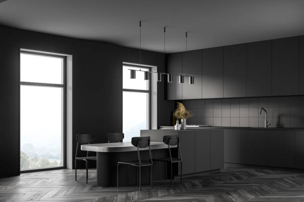 istock Dark modern kitchen interior near window. Dining area with table. Wooden parquet floor. Panoramic window. 1309733051