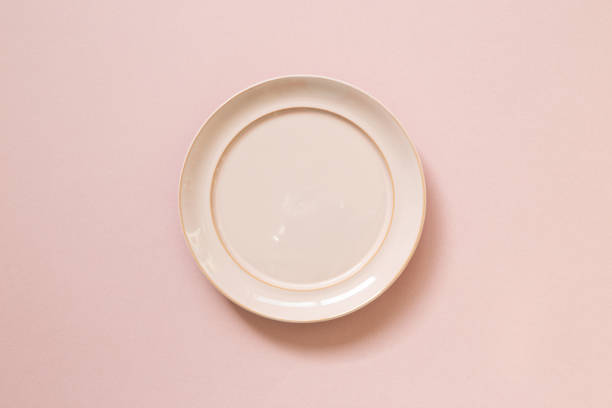 istock Empty ceramic round plate isolated on pink background. top view 1309734758