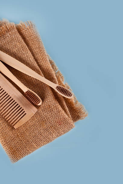 istock Eco-friendly bamboo teeth brushes and hairbrush on the wooden table. Zero waste. Top view. 1309737111