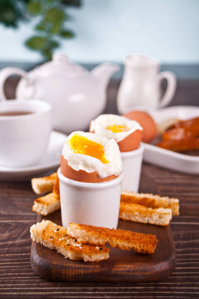 istock boiled egg in eggcup on wooden board with crispy toast. 1309737157