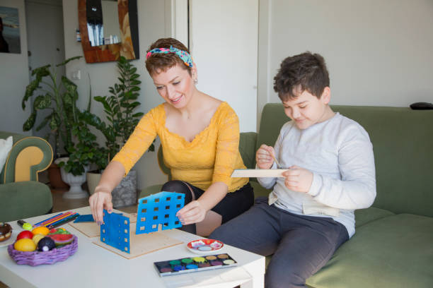 istock Mother and son painting a building model 1309738899