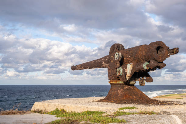 istock Old Rusty Cannon Against Cloudy Sky And Sea At Summer Day. 1309738912