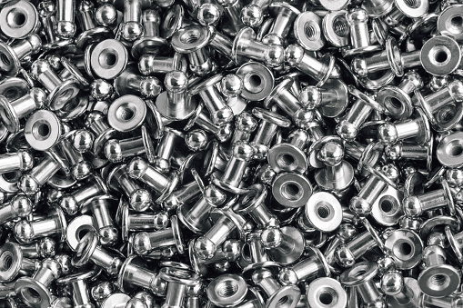 macro background of sewing accessories - grommet, rivet, snap, button.
