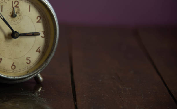 istock Old and retro alarm clock on wooden surface. Vintage background 1309741482