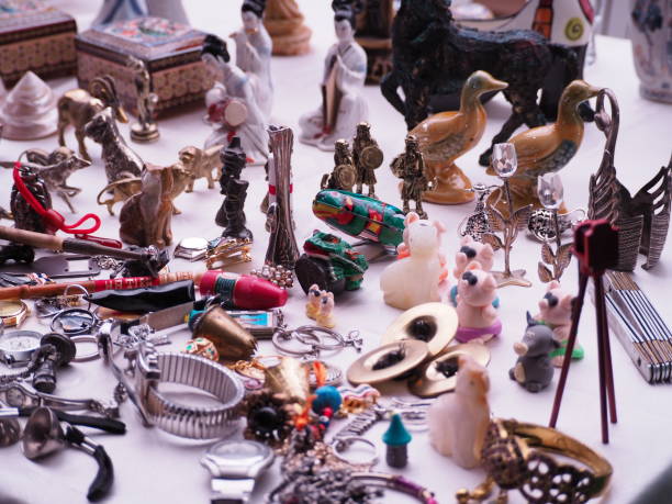 Top-down view of a flea market stall in Berlin displaying a colorful assortment of vintage and second-hand items. The collection includes porcelain figures, miniature teapots, brass trinkets, small toys, and various curiosities. A vibrant and nostalgic glimpse into flea market culture.