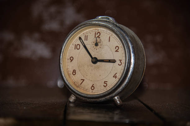 istock Old and retro alarm clock on wooden surface. Vintage background 1309741569