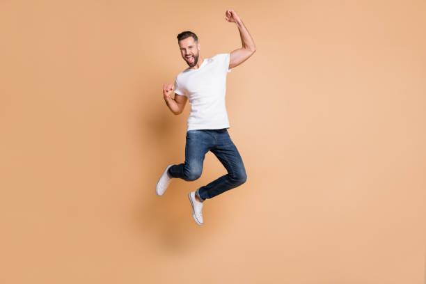 istock Full length body size view of nice tall cheerful macho guy jumping rejoicing having fun isolated over beige pastel color background 1309746924