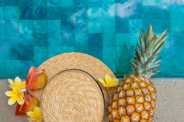 istock Summer concept. Hat, glasses, pineapple by the pool. 1309748247