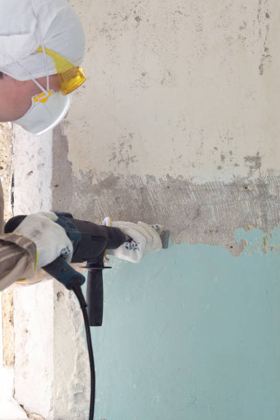 istock Worker removes old paint from a concrete wall 1309748938