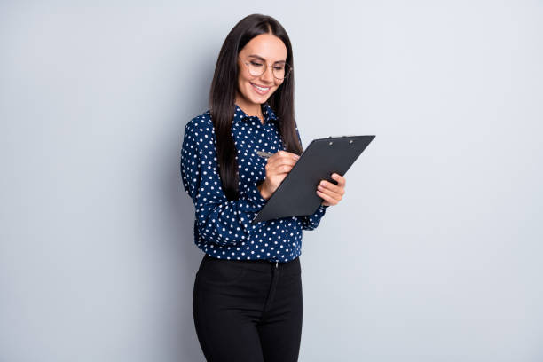 istock Portrait of pretty focused cheery business lady writing document clipboard note plan idea isolated on grey pastel color background. 1309749923