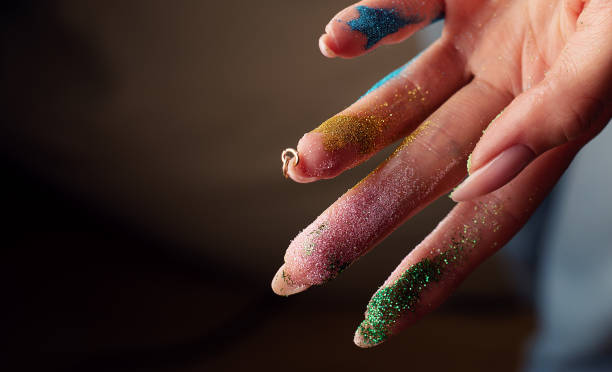 istock Cosmetic sequins on female fingers 1309752550