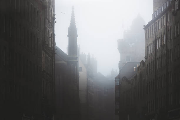 Haunting, spooky and moody atmospheric old town Edinburgh along the medieval Royal Mile in misty fog.